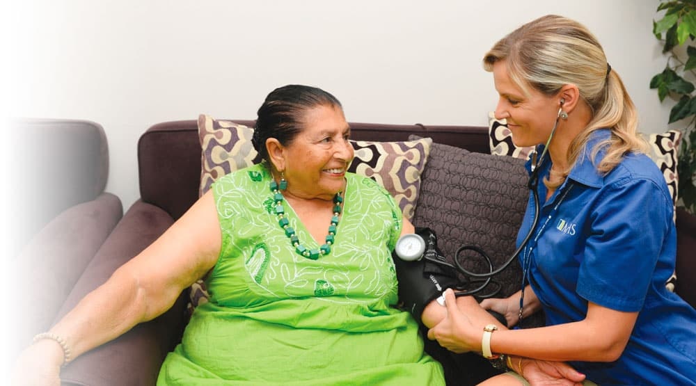 MJHS Health System Staff Member Taking Blood Pressure of Smiling Patient