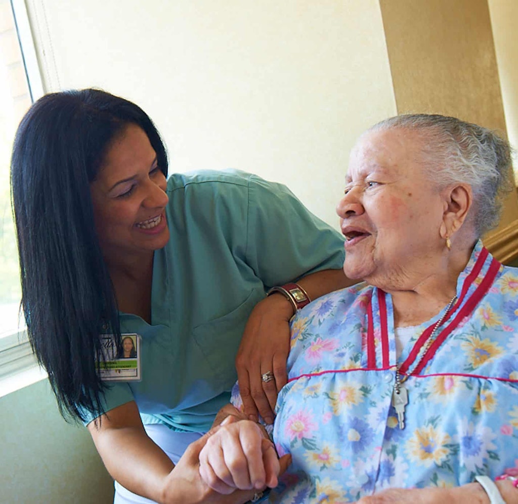 Una cuidadora de Isabella sonríe y se ríe con una paciente