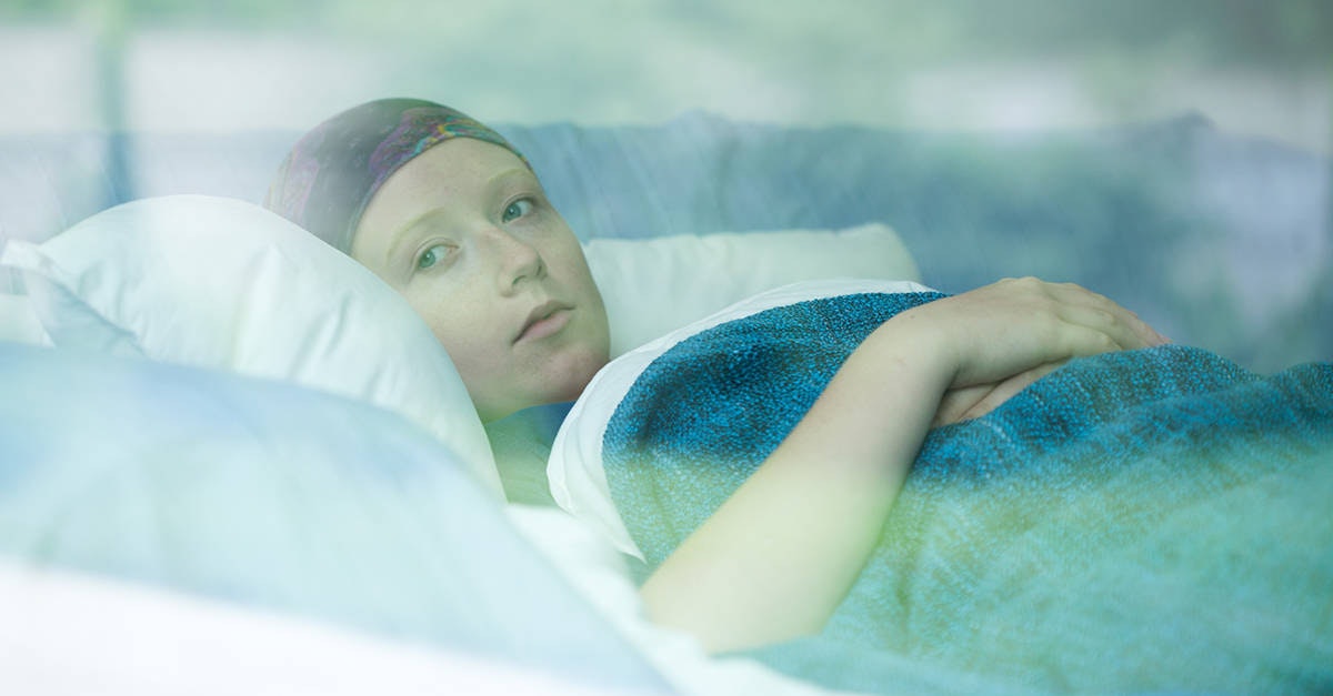 Mujer joven enferma de cáncer en una cama