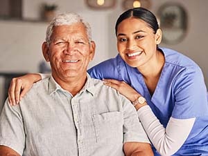 An elderly man and a caregiver posing for a photo.