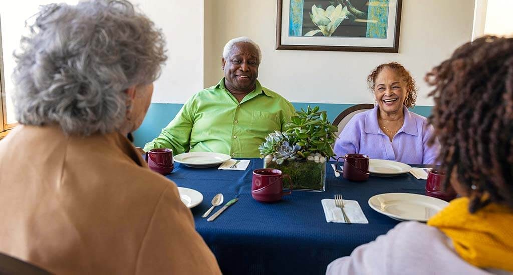 At a dining table, residents are having an enjoyable talk.