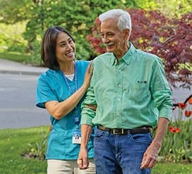 A caregiver accompanying a resident on an outside stroll.